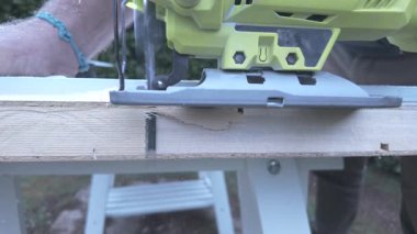 Kablosuz elektrikli testerenin yanal çekimini kapat. Tahta kapı kenarında dar bir kesik aç.