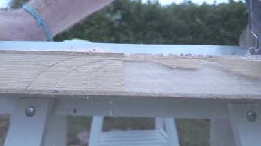 Dışarıdaki kapı kenarındaki kablosuz elektrikli testerenin yeni ahşap kesiminin detaylı görüntüsü.