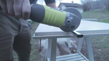 Parlatıcının sağ tarafının alüminyum çubuğu kıvılcımlar gibi kestiğini gösteren yanal çekim.