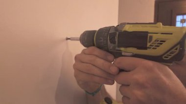 Vida sürücü bit ile kablosuz elektrik aracı kullanıcı sabit basınç uygularken yan düşük perspektiften duvar meşgul
