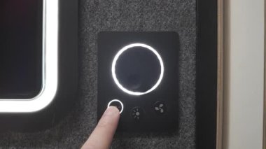 Kullanıcı akıllı bir ev panelindeki ışık kontrol düğmelerine basar, yumuşak beyaz aydınlatmayı gösterir ve merkezi yoğunluk tuşunu vurgular