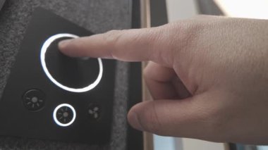 Alttaki bir düğme hafifçe yanarken, akıllı loş kadranı döndüren bir elin çapraz düşük görüntüsü