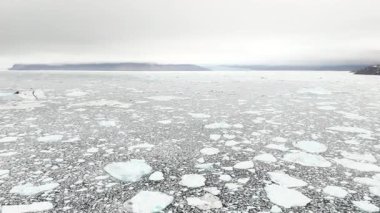 Yavaş dairesel hareket, donmuş okyanusu tüm yönlere, uzak engebeli dağlara, bulutlu gökyüzüne ve ezici kutup büyüklüğüne serer..