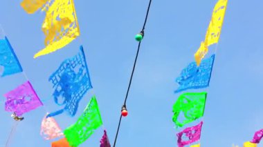 Dinamik yakınlaşma, açık havada yüzen çok renkli bayrakları ve ampulleri, güneşli koşulları, yoğun mavi gökyüzünü, canlı yaz atmosferini ortaya çıkarır.