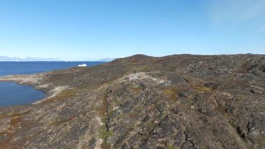 İleri hareket, yosunlu kıyı şeridine kayar, uzak bir gözlemciyi geçer, sonra izolasyon, buz ve geniş ufku ortaya çıkarmak için yükselir.