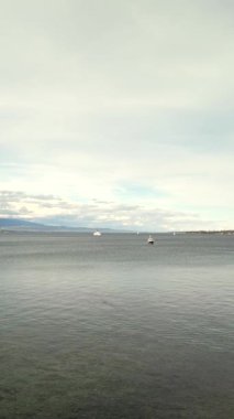 Statik çerçeve, suyun yavaş hareketini, hafif rüzgar dalgalarını, Jura dağlarını ve bastırılmış bahar sükunetini vurgular..