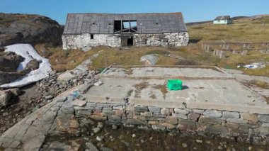 Grönland 'da uzak bir kutup bölgesindeki harabe bir binanın üzerinde uçan hava manzarası.