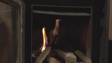 Parlak turuncu alevler ve yanan közler karanlık dökme bir demir ocakta sıcak bir ortam sağlıyor.