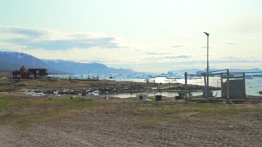 Grönland 'da kutup okyanusunda yüzen buzdağlarıyla Saqqaq köyünün çarpıcı manzarası.