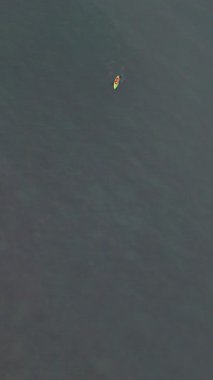 Yalnız kanocu, Karayipler 'in açık okyanus sularında renkli bir teknede kürek çekiyor.