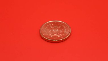 Beyaz arkaplanda izole edilmiş bir kırmızı sikke.