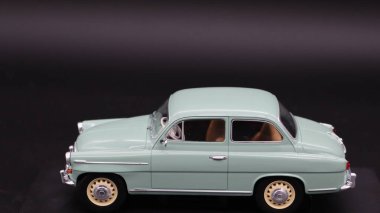 Mavi ve yeşil arka planı olan klasik bir araba.