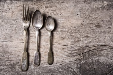 Tahta masadaki eski çatal bıçak takımı.