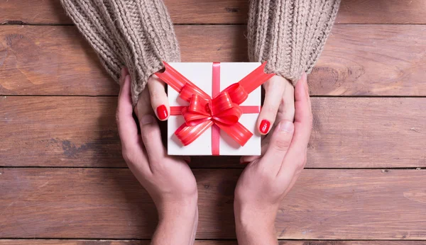 Frau mit Mann hält ein Weihnachtsgeschenk in der Hand — Stockfoto