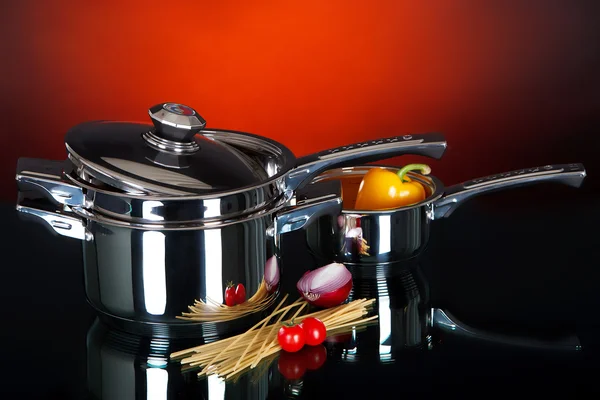 A set of pots and pans on a dark background — Stock Photo, Image