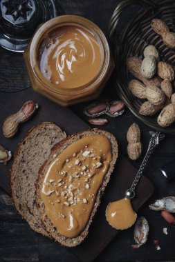 Ahşap Arka Planda Kabuklu Fıstıklı Cam Kavanozda Organik Fıstık Ezmesi. Sağlıklı Kahvaltı Vejetaryen Gıda Kavramı.