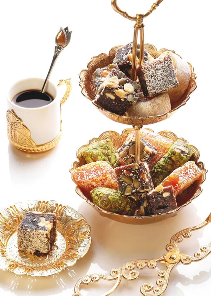 Turkish sweets with nuts and coconut on a white plate. Organic food.