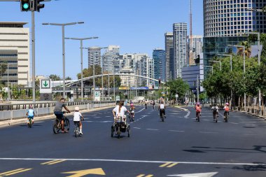 Tel Aviv, İsrail -02 Ekim 2025: Aileler ve insanlar Tel Aviv 'de boş bir şehir sokağında bisiklet sürüyor. Yom Kipur Ulusal Bayramında Boş Tel Aviv caddeleri