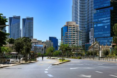 Tel Aviv, İsrail -02 Ekim 2025: Yom Kipur sırasında Tel Aviv 'de boş sokaklar, arabalar kaybolduğunda ve insanlar gökdelenlerle çevrili sakin şehirde bisiklet sürerken.