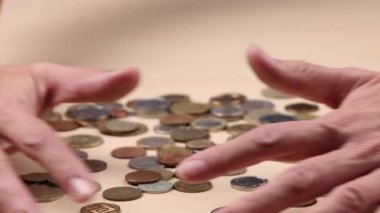 Eller masadan bozuk paraları alır ve çerçeveden çıkarır. Para yönetimi kavramı, harcamalar, tasarruflar, nakit kontrolü ve finansal rutin. En az bir çekim stüdyo videosu.