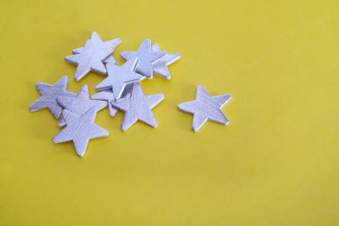 Geleneksel Noel sarı arka planda gümüş yıldızlarla harfleri karşılamak veya duyurmak için