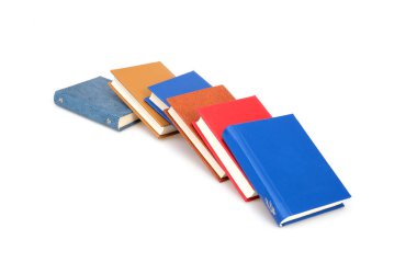 Beyaz arka planda izole edilmiş beyaz çarşaflı renkli kapaklı kitap yığını