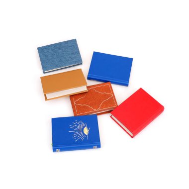 Beyaz arka planda izole edilmiş beyaz çarşaflı renkli kapaklı kitap yığını