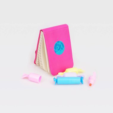 Beyaz arkaplanda izole edilmiş pembe not defteri ve çok renkli işaretleyiciler ile kompozisyon (mockup)