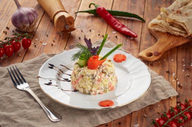 Ahşap arka planda et ve sebzeli geleneksel Rus salatası Olivier.