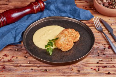 Patates püresi ve ahşap arka planlı tavuk şnitzel.