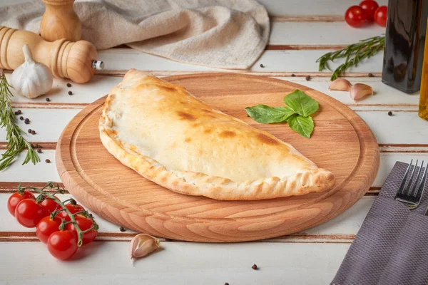 Dilimlenmiş pizza, sos ve otlar, ahşap beyaz arka plan