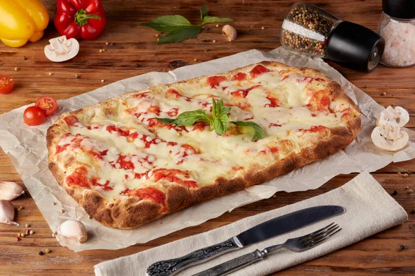 Roman pizza, variant of classic Italian pizza, wooden background