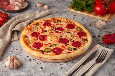 Dilimlenmiş pizza, sos ve otlar, dokulu arka plan.