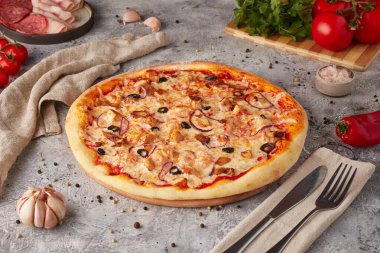 Dilimlenmiş pizza, sos ve otlar, dokulu arka plan.