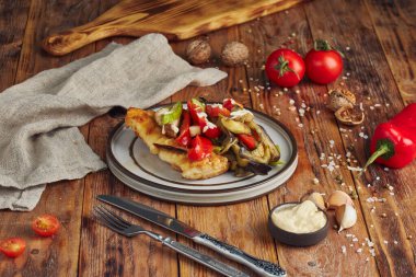 Tavada kızartılmış hake balığı filetosu, peçeteli ahşap arka plan.