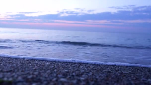 Las olas del mar en la arena se cierran. puesta de sol en la playa . — Vídeo de stock