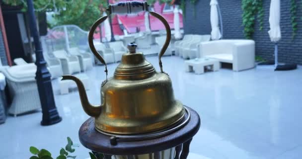 Старый медный чайник во дворе под дождем — стоковое видео