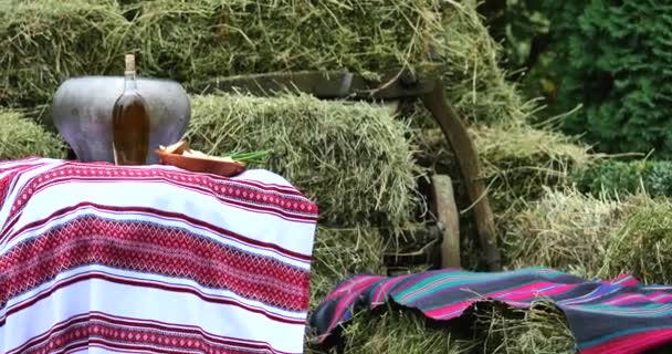 Lunch on bales of hay. woven cloths in the manger. Food with a bottle in bales of hay. — Stock Video