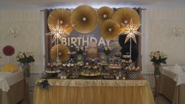 Fiesta de cumpleaños buffet dulce. buffet dulce oro con estrella ligera . — Vídeo de stock