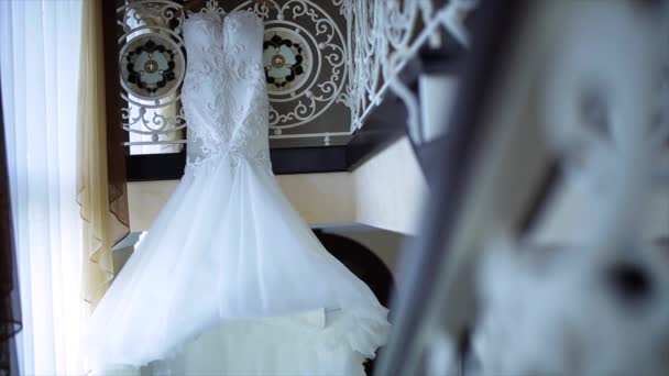 Hermoso vestido de novia blanco colgando por la ventana — Vídeo de stock