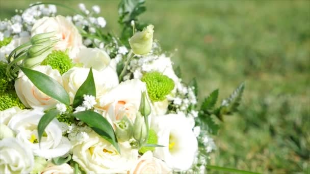 Bridal bouquet lying on green grass — Stock Video
