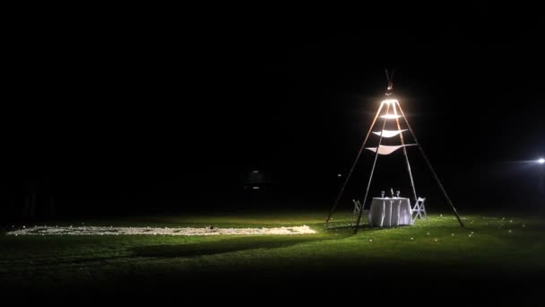 Tabel instellen voor het diner op het gras in de nacht — Stockvideo