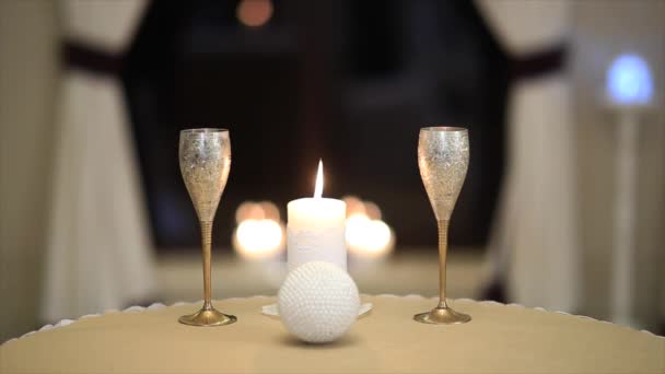 Стіл для двох налаштувань зі склянками та свічкою — стокове відео