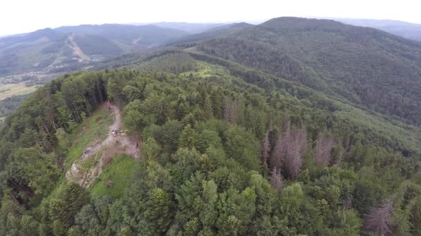 O cume de montanha coberto da floresta com a bandeira. Paisagem montesa. Drone de vídeo . — Vídeo de Stock