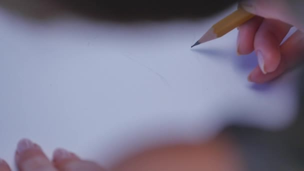 Ludzkie ręce z ołówek pisać na papierze, na tle biały stół — Wideo stockowe
