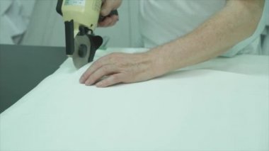 Kadın moda Studio masada bir bez parçası kesme.