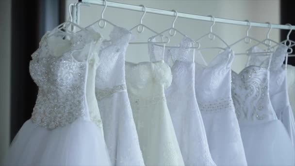 Vestidos de novia colgando en bastidores — Vídeo de stock