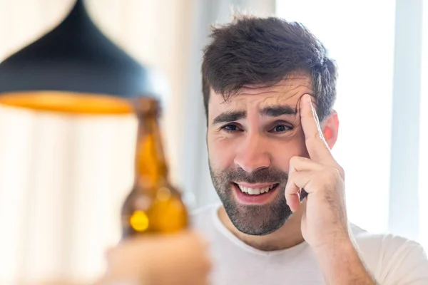 Foto de homem barbudo olhando para a cerveja no fundo branco. — Fotografia de Stock