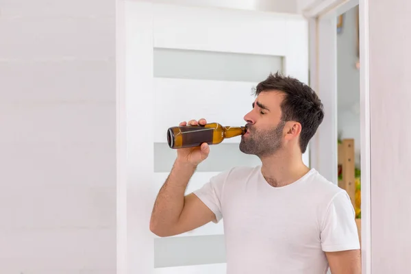 Vista lateral do homem barbudo bebendo cerveja fresca. — Fotografia de Stock