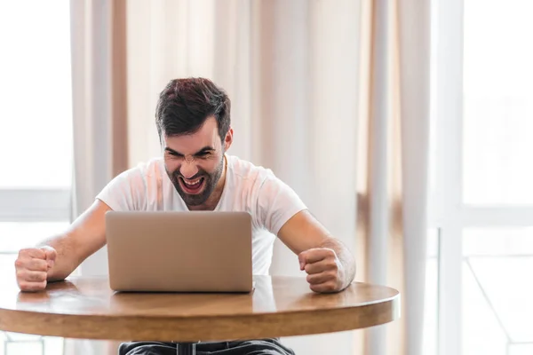 Photo of mans reaction while communicating with workers online.